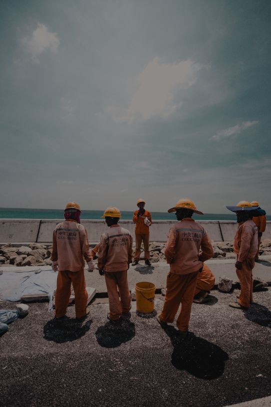 Image shows workers standing at a constuction site. Image by Ahmed Nishaath. Source https://unsplash.com/photos/s4g-5YjSoh4